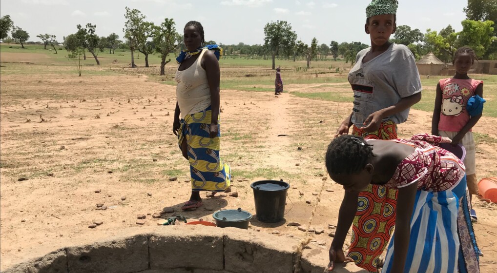 Indsamling Himmelske Dage Mennesker ved en brønd i et tørt landskab i Afrika