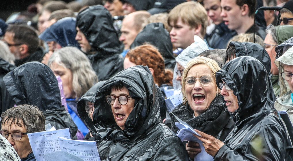 Himmelske Dage Mennesker som synger i regnvejr ved Himmelske Dage